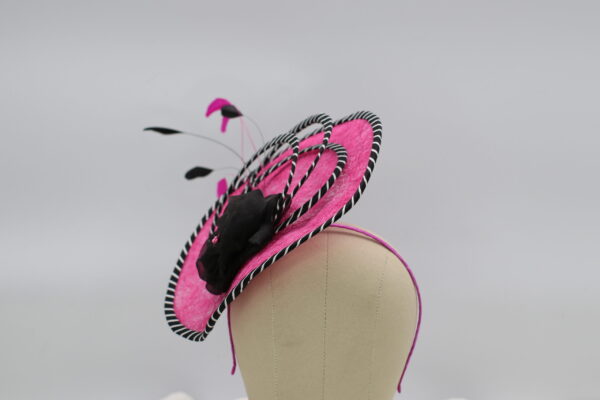 Pink and black fascinator hat with black and white striped edging