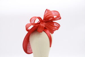 Red sınamay fascinator base with red ribbon swirls looped over the fascinator